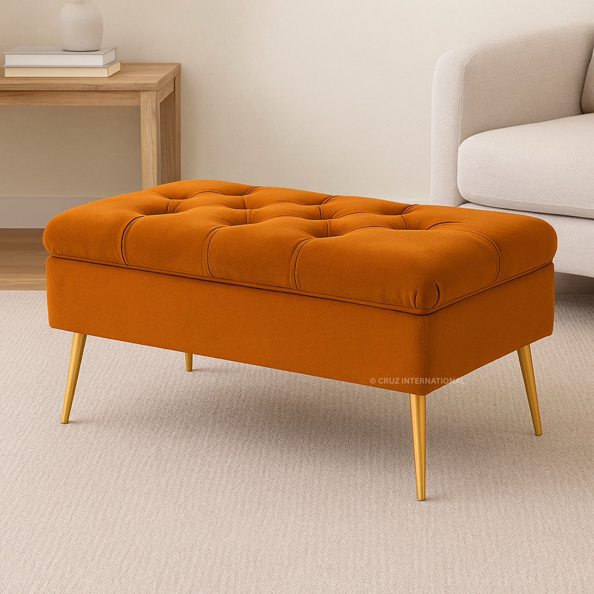 Orange tufted ottoman with gold legs in a living room setting