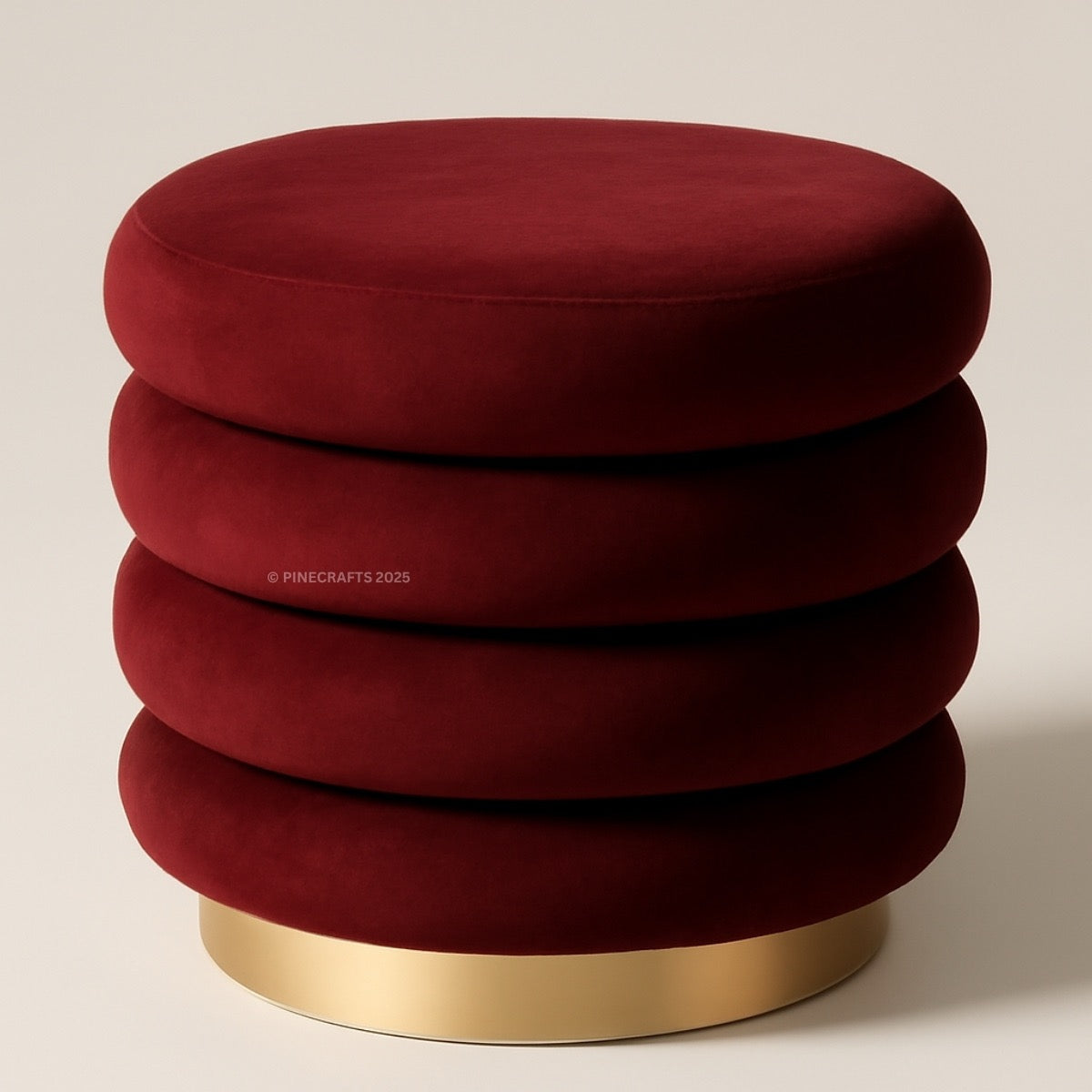 Red velvet ottoman with a gold base on a beige background