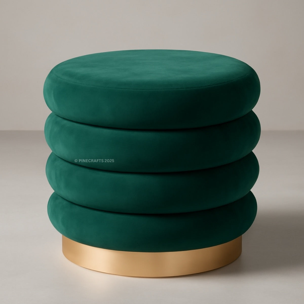 Green velvet ottoman with a gold base on a neutral background