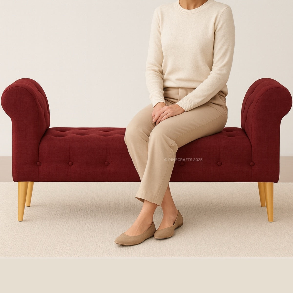 Person sitting on a red bench wearing beige pants and a cream sweater.