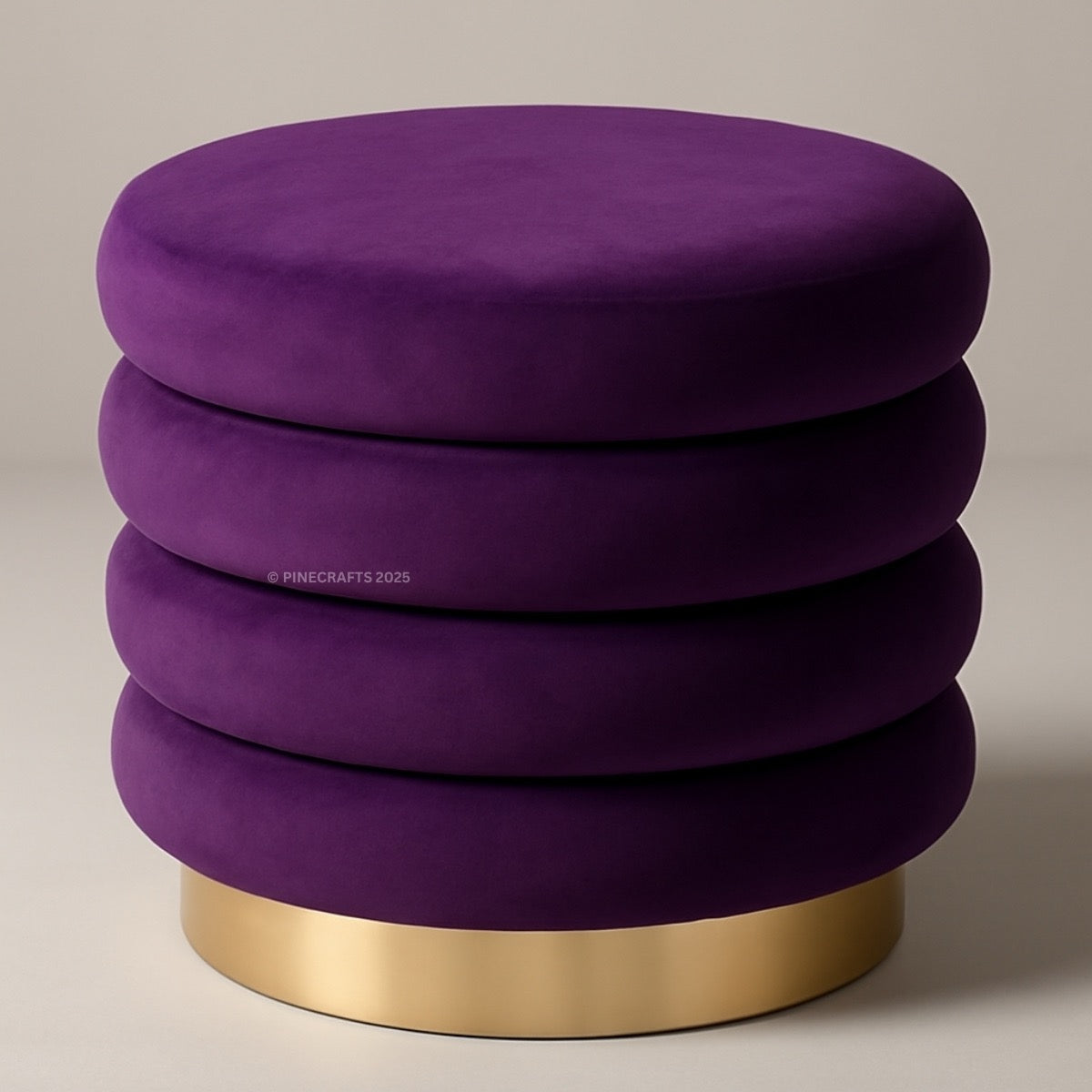 Purple ottoman with a gold base on a beige background