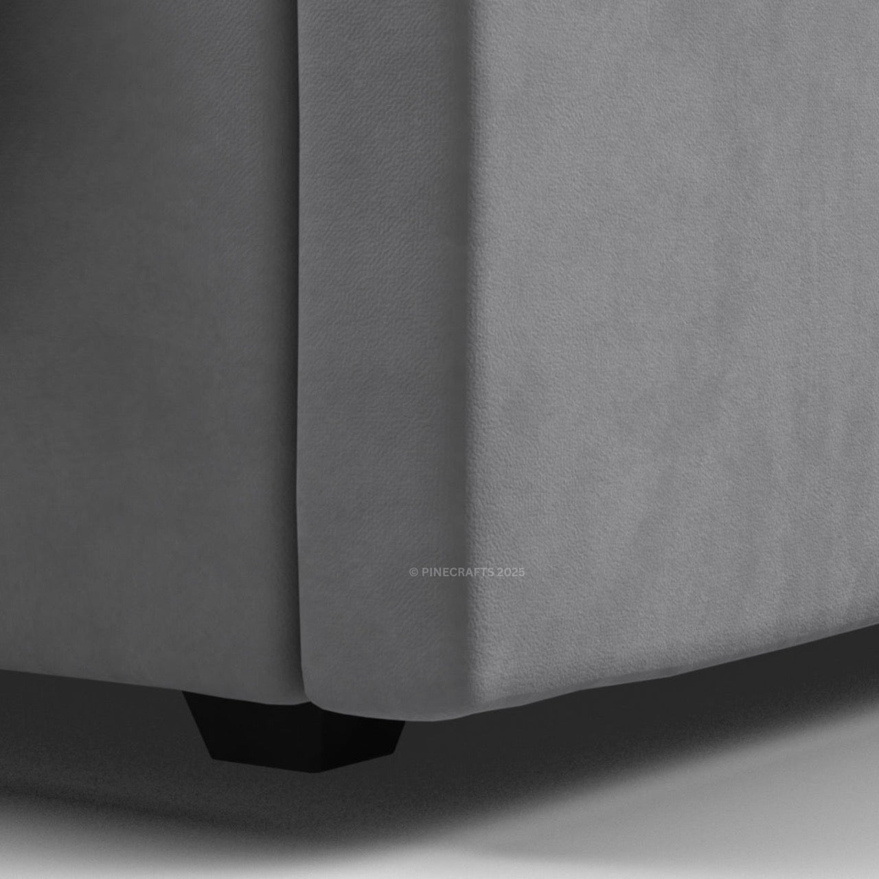 Gray upholstered corner of a piece of furniture with a visible brand logo.