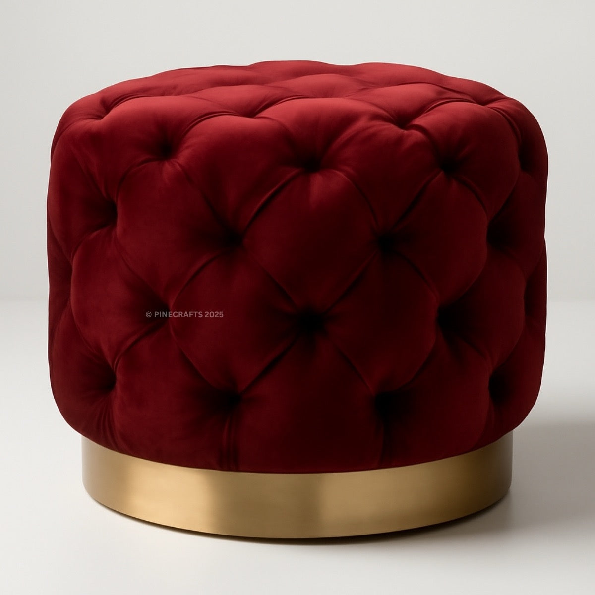 Red tufted ottoman with a gold base on a white background