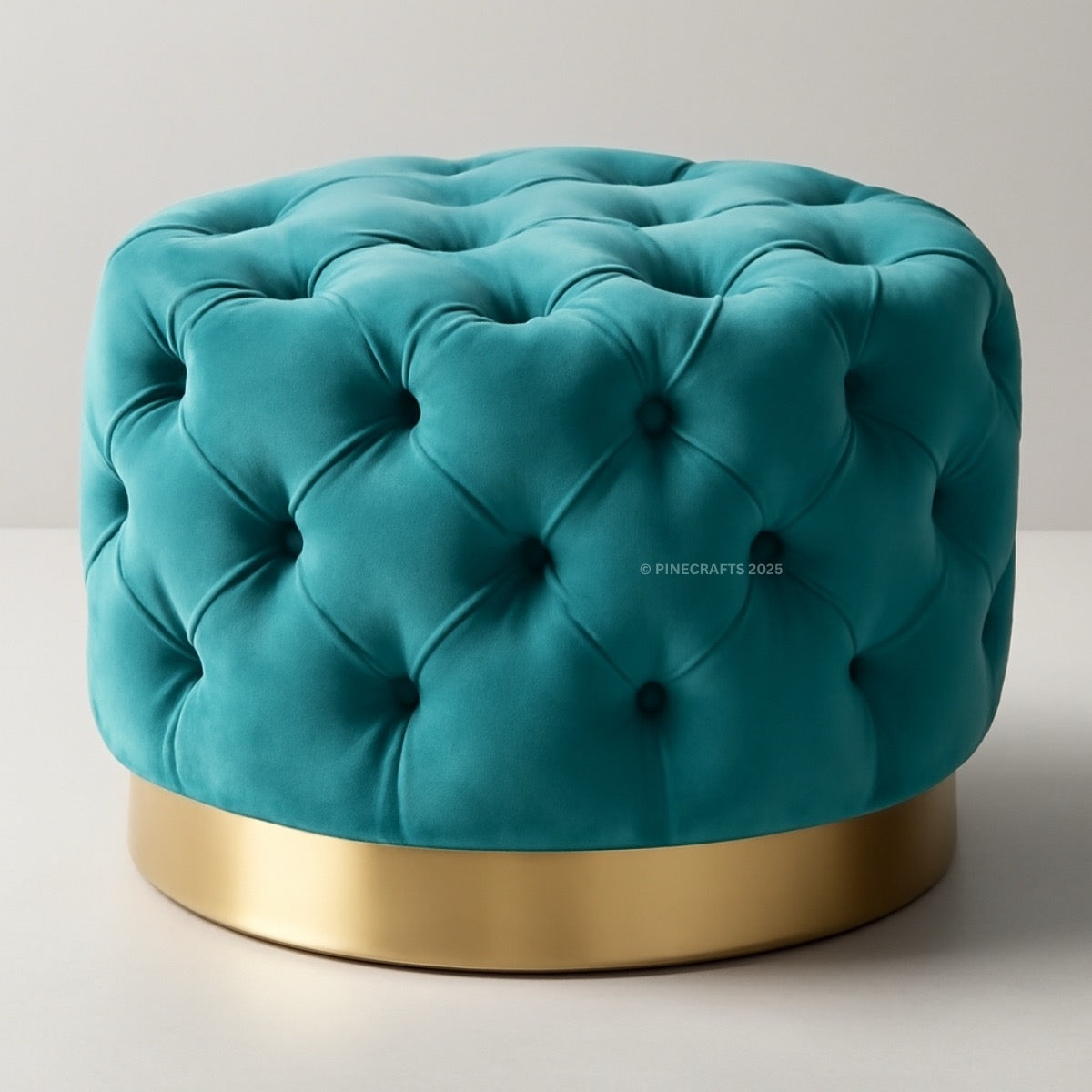 Teal tufted ottoman with a gold base on a light gray background
