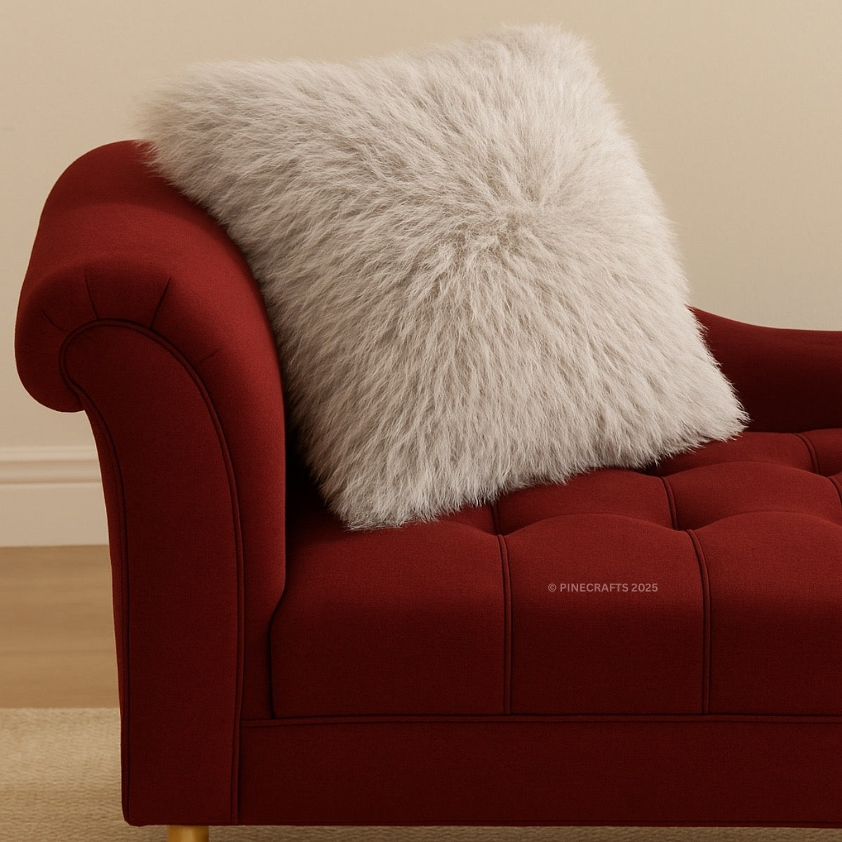 Red sofa with a fluffy gray pillow on a beige background