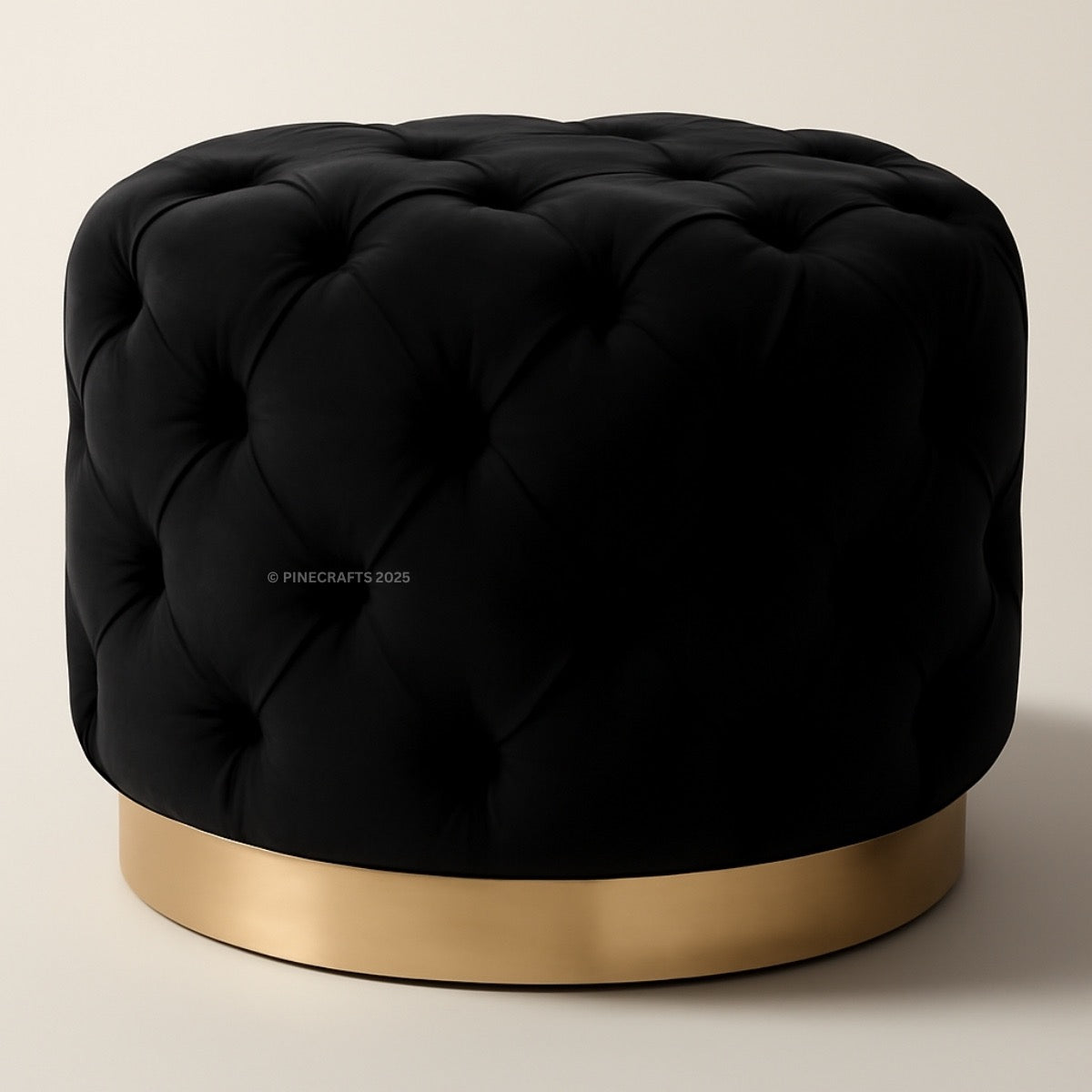 Black tufted ottoman with a gold base on a beige background