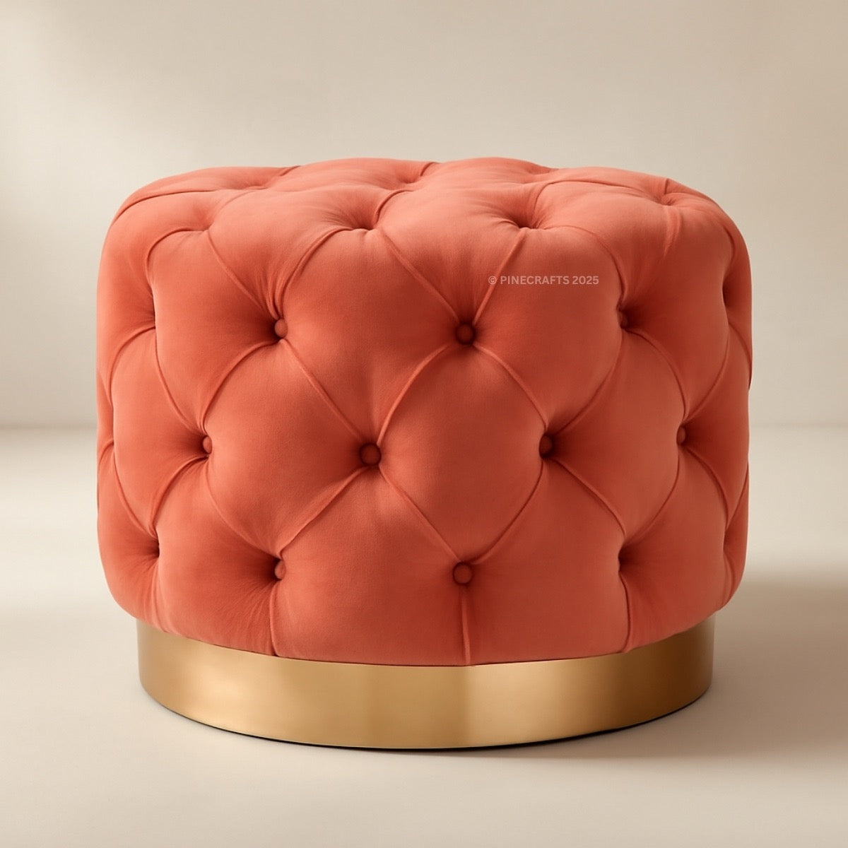 Coral tufted ottoman with a gold base on a beige background