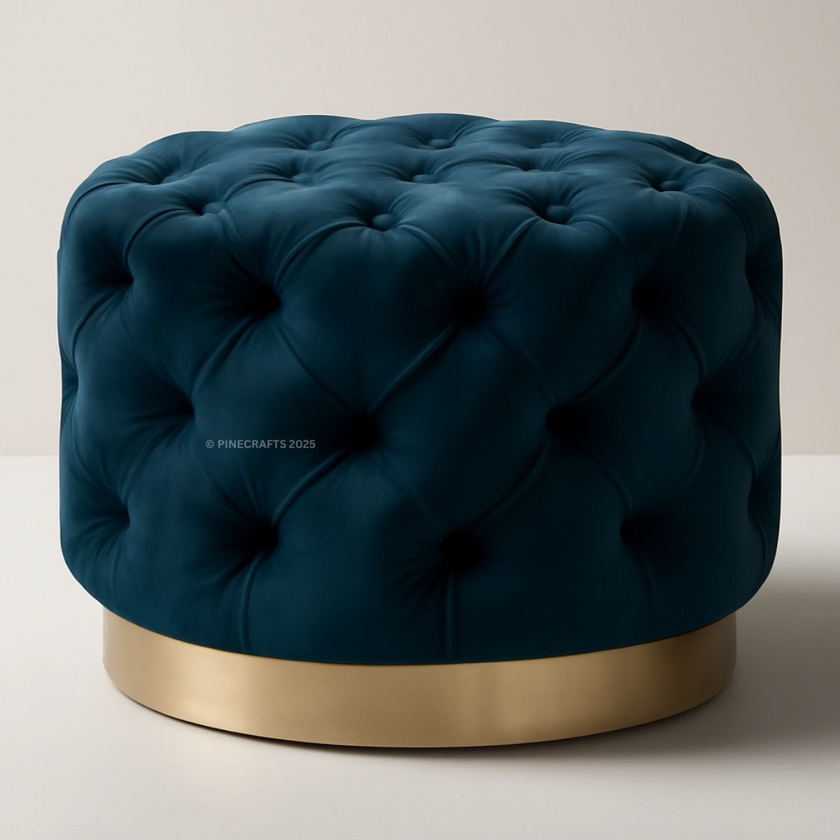 Blue tufted ottoman with a gold base on a light background