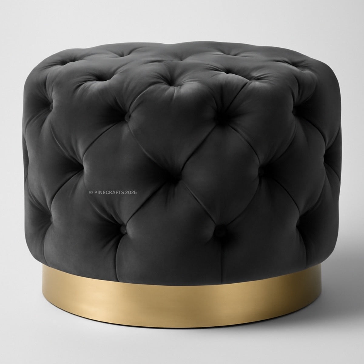 Black tufted ottoman with a gold base on a white background