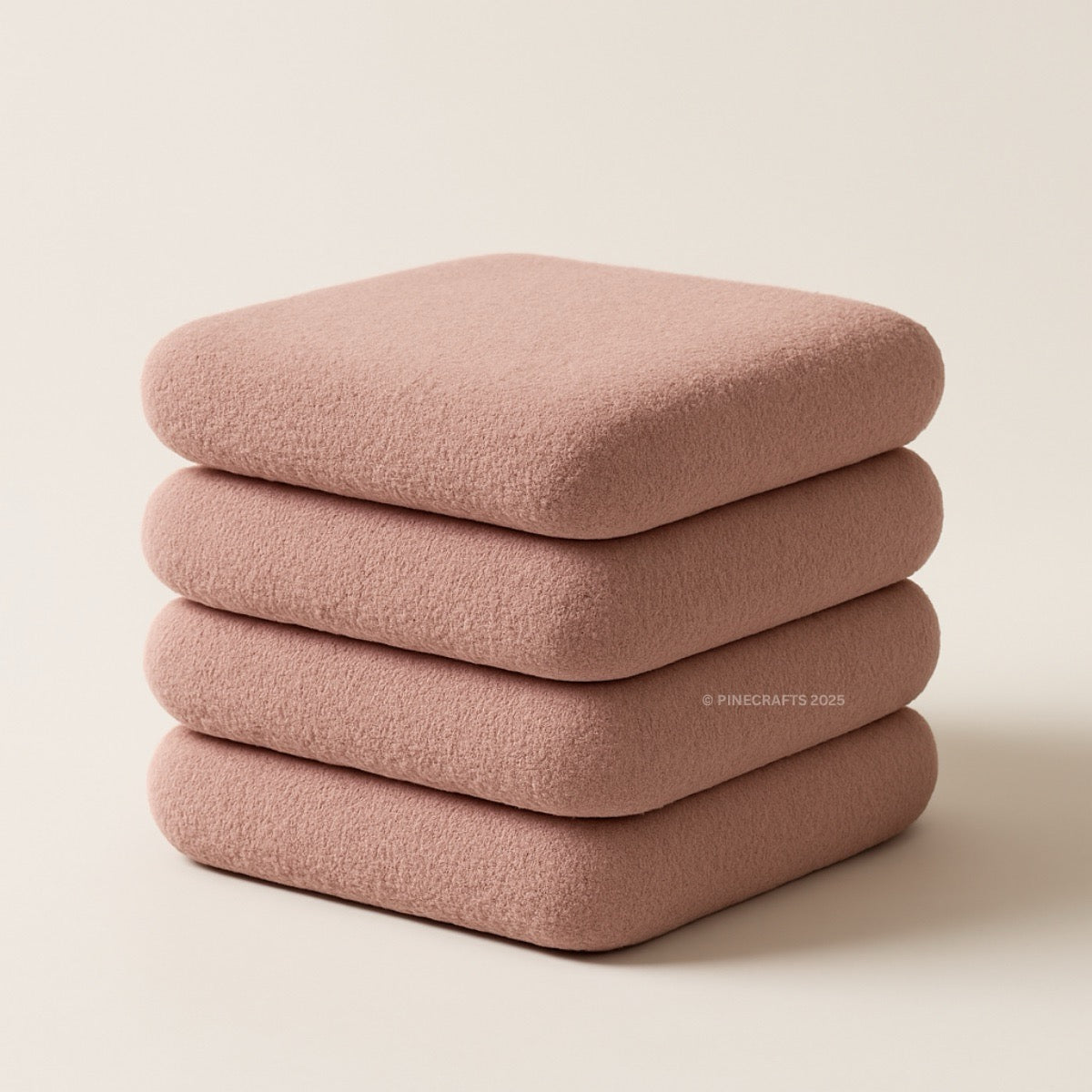 Stack of four pink cushions on a beige background