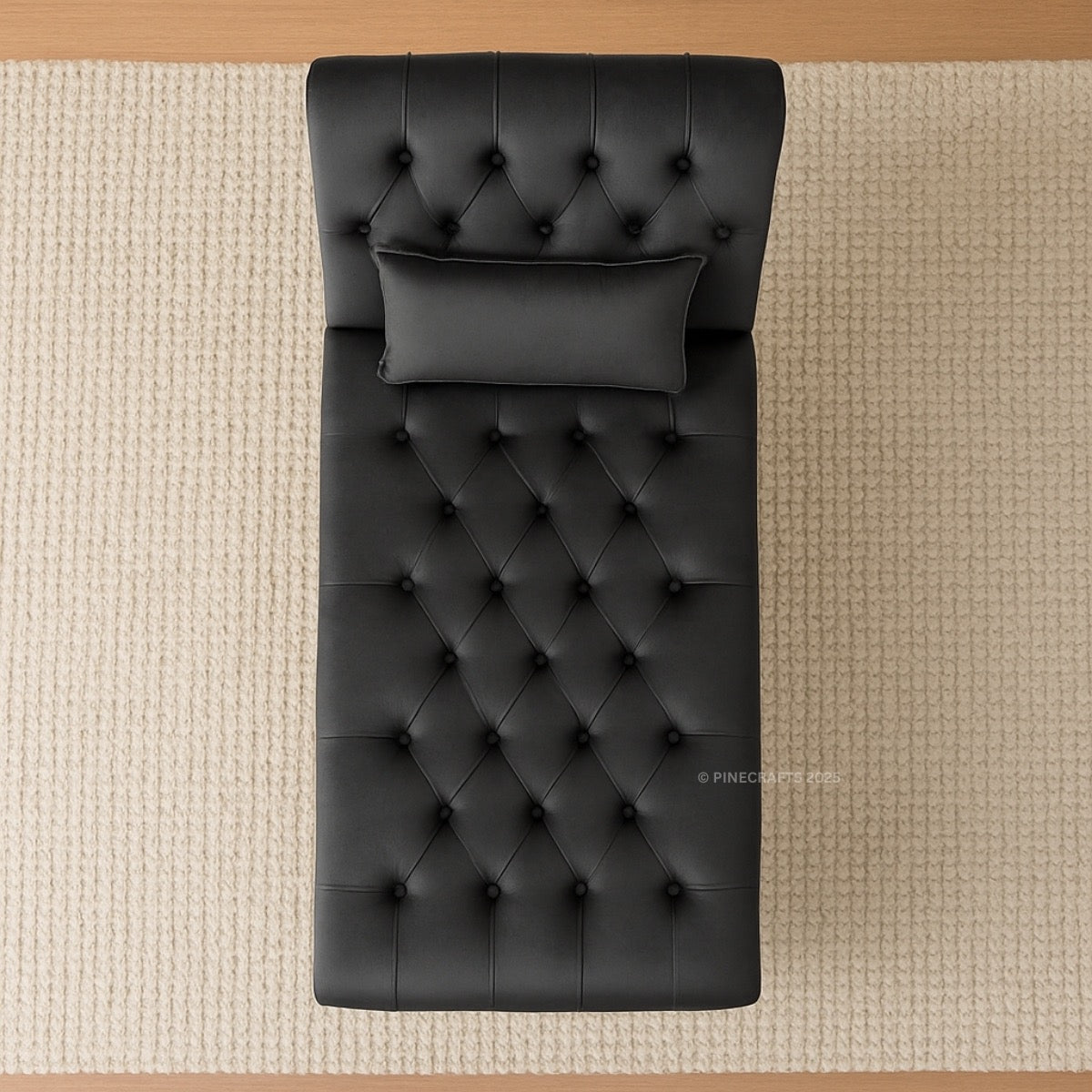 Black tufted headboard and matching pillow on a beige textured surface