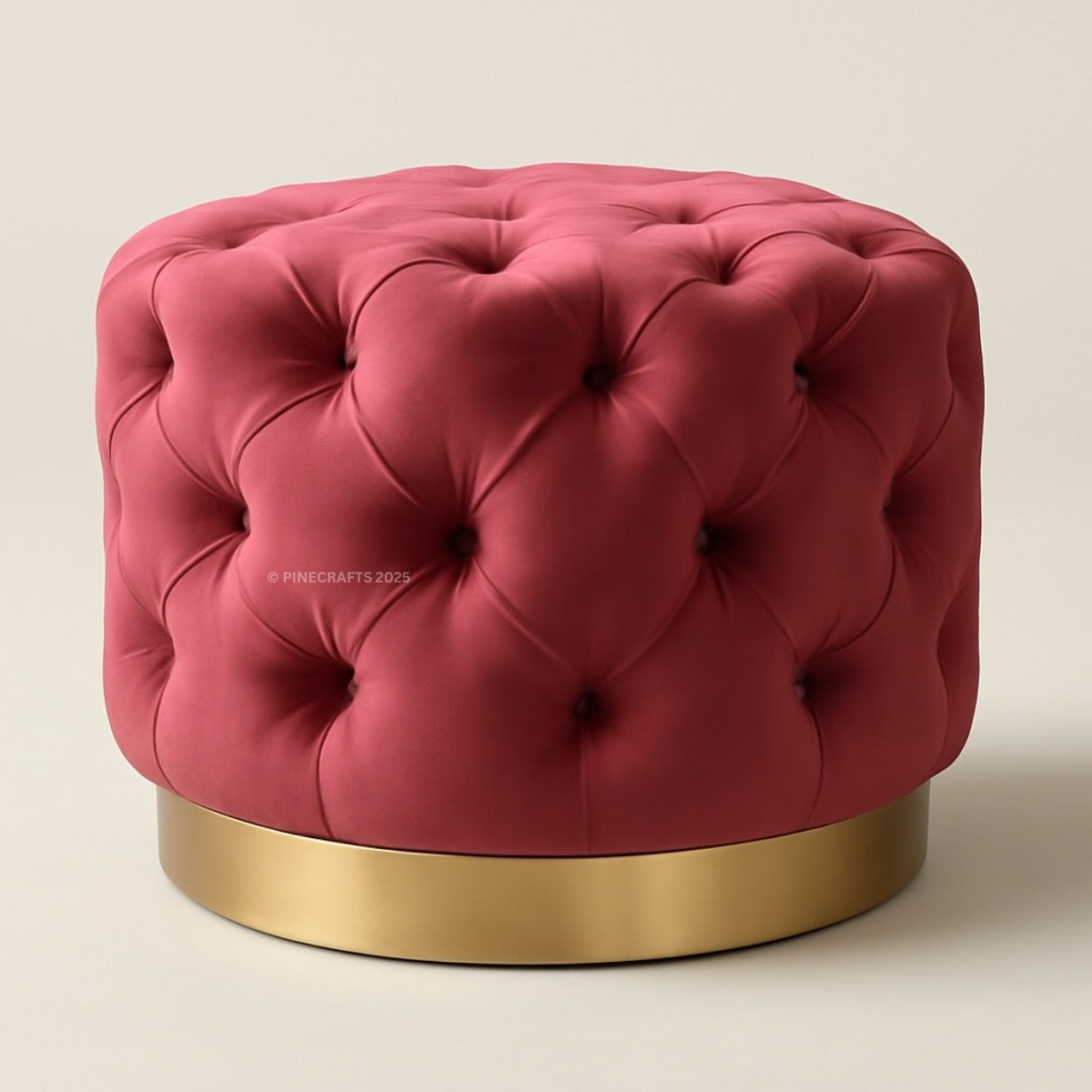 Pink tufted ottoman with a gold base on a beige background