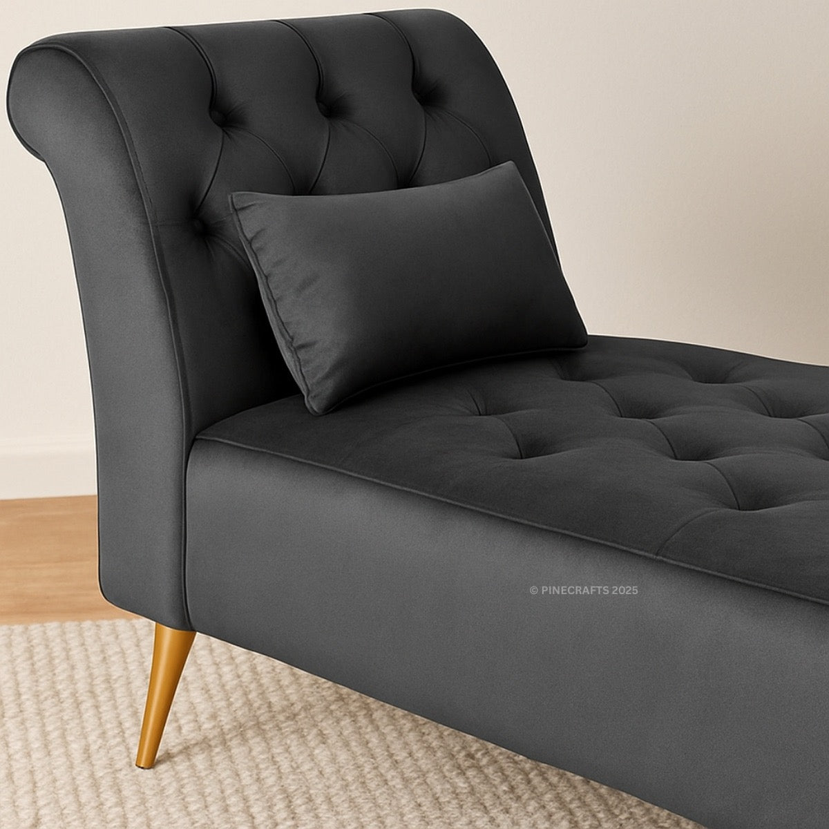 Gray tufted chaise lounge with a pillow on a beige background