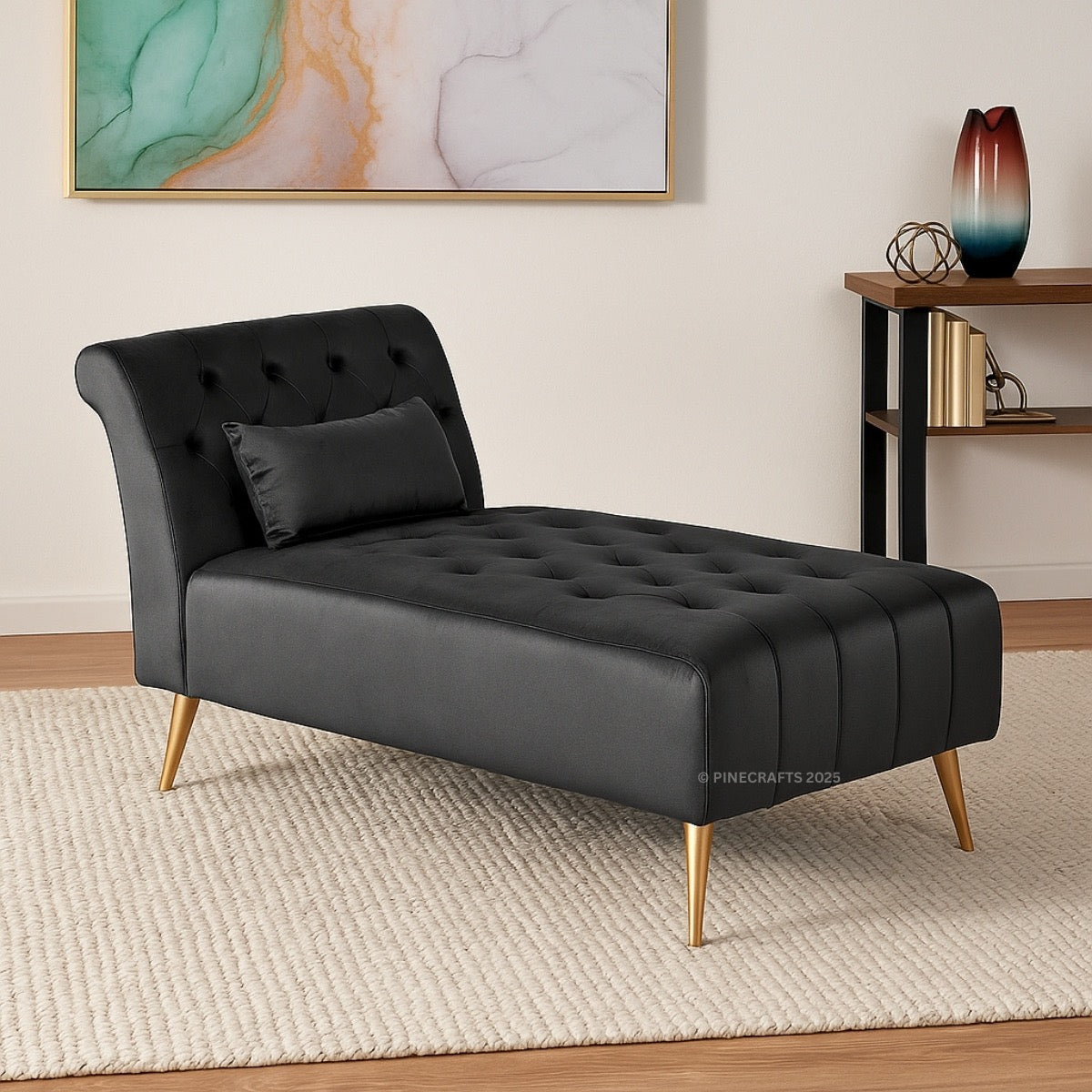 Black tufted chaise lounge with gold legs in a room setting.