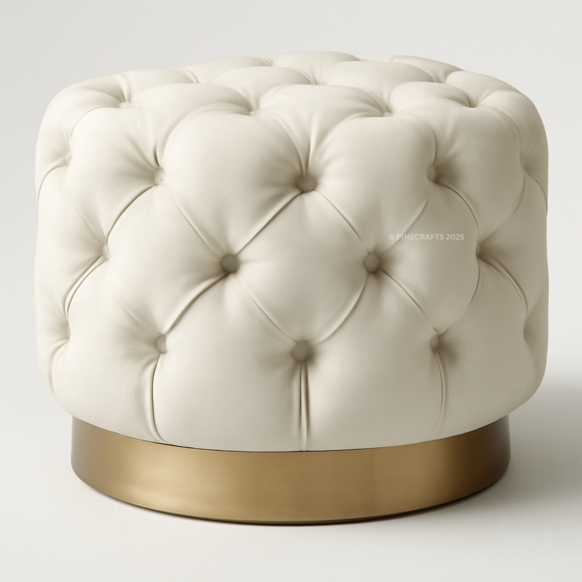 White tufted ottoman with a gold base on a white background