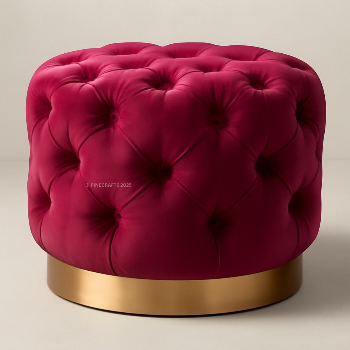 Pink tufted ottoman with a gold base on a beige background