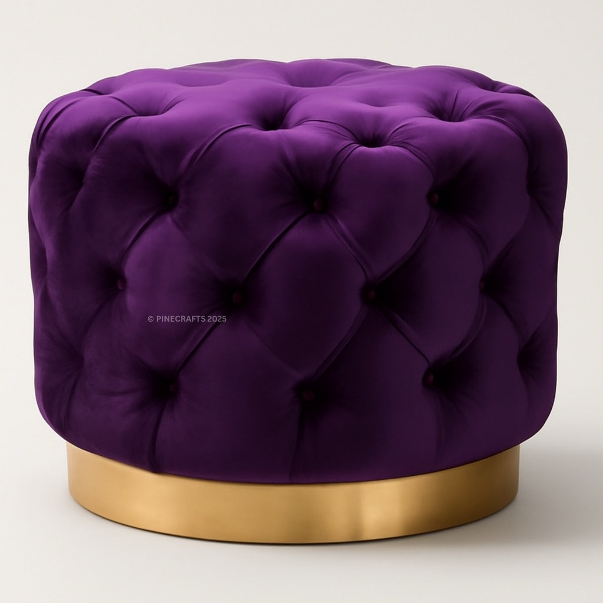 Purple tufted ottoman with a gold base on a white background