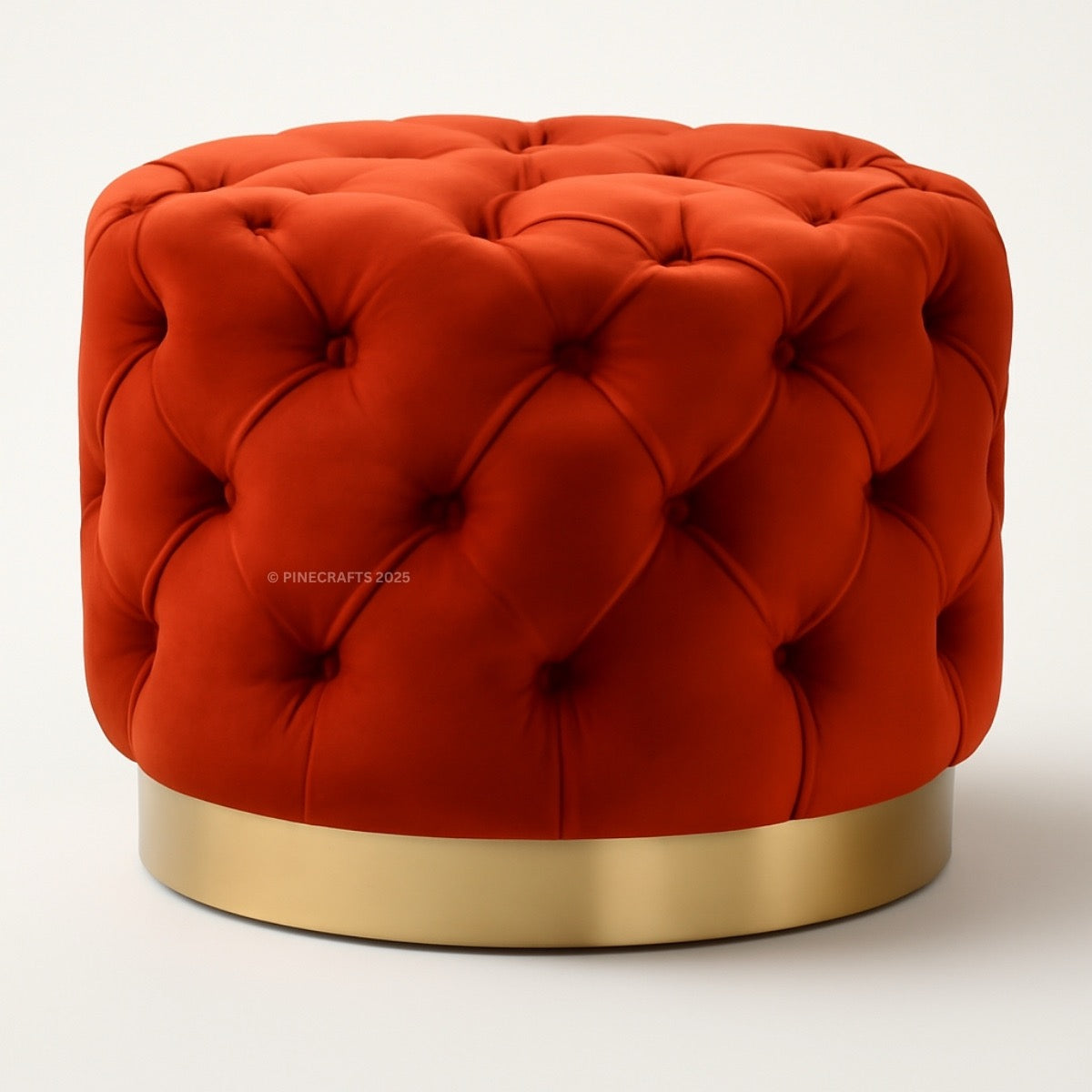 Red tufted ottoman with a gold base on a white background