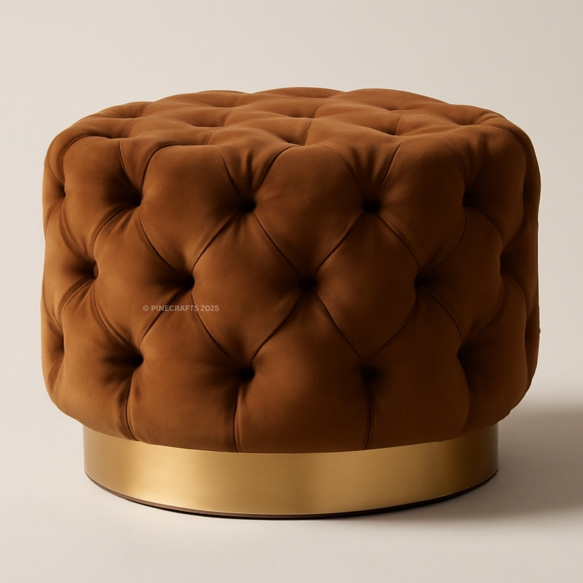 Brown tufted ottoman with a gold base on a beige background