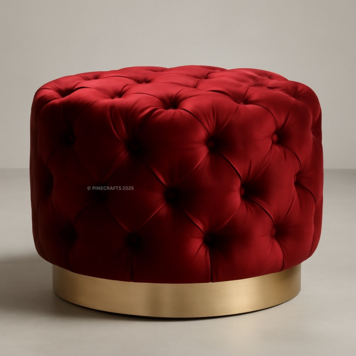 Red tufted ottoman with a gold base on a neutral background