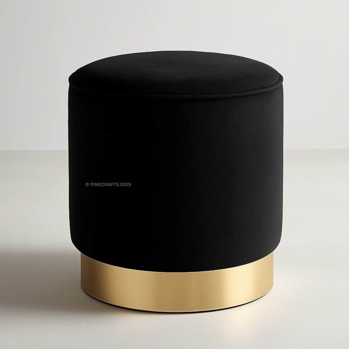 Black ottoman with gold base on a light gray background