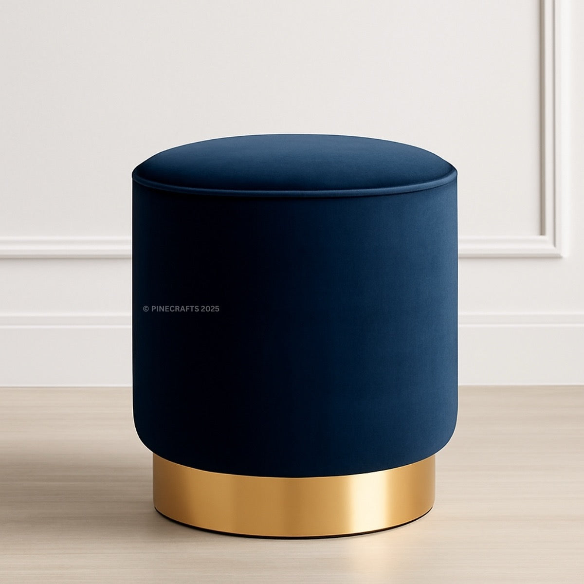 Blue ottoman with gold base on a light wooden floor