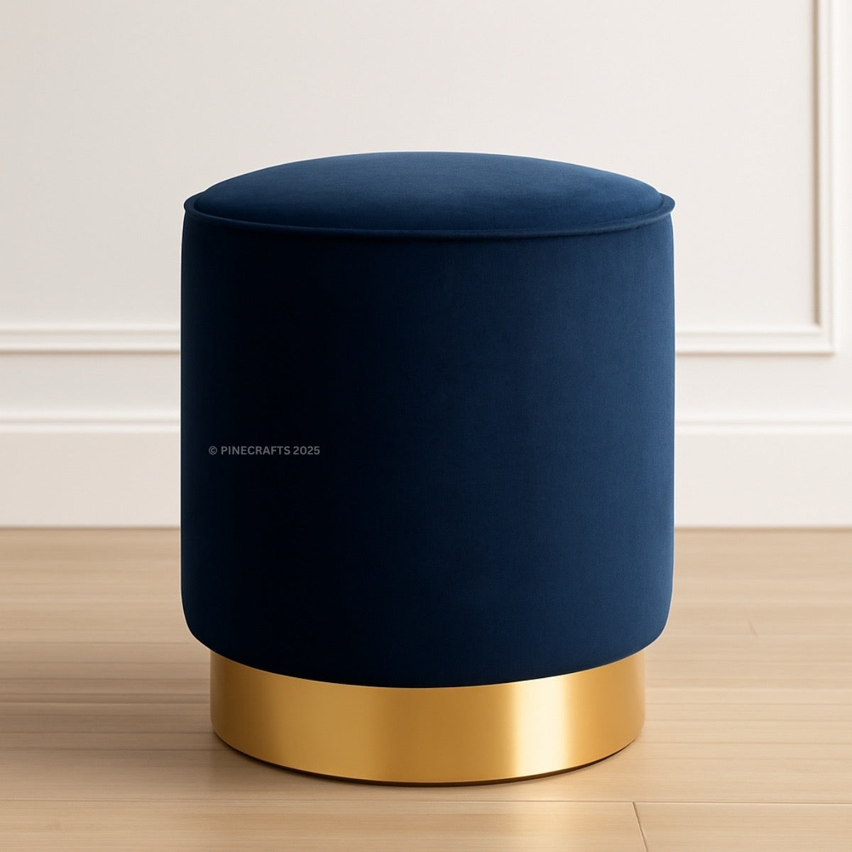 Blue ottoman with gold base on a wooden floor