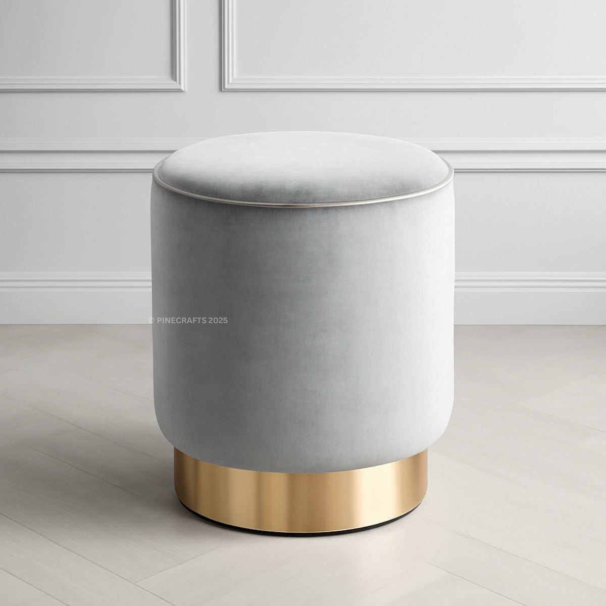 Gray ottoman with gold base on a light wooden floor