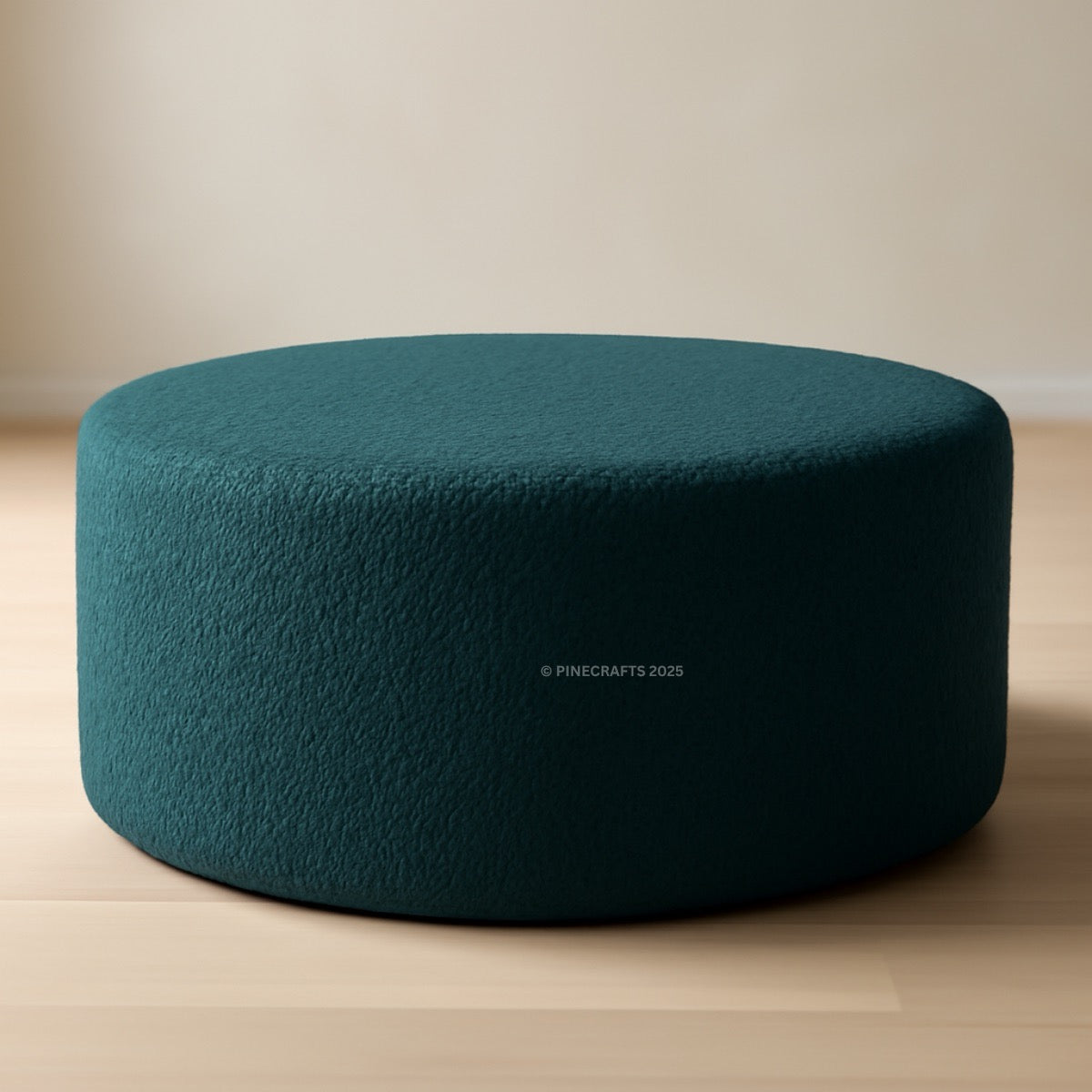 Teal ottoman on a wooden floor with a neutral background
