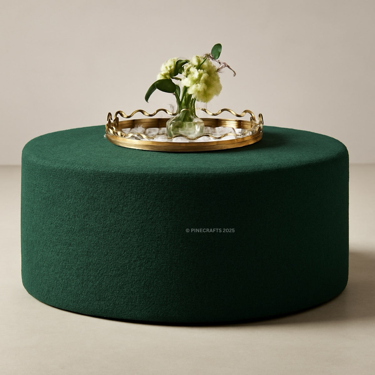 Green round ottoman with a gold tray and flowers on a beige background
