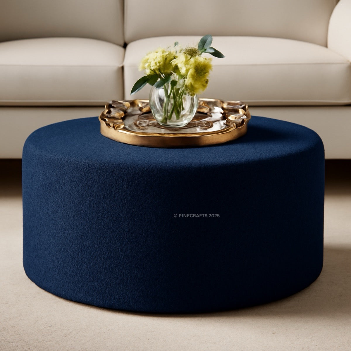 Blue ottoman with a gold tray and yellow flowers on a beige couch background