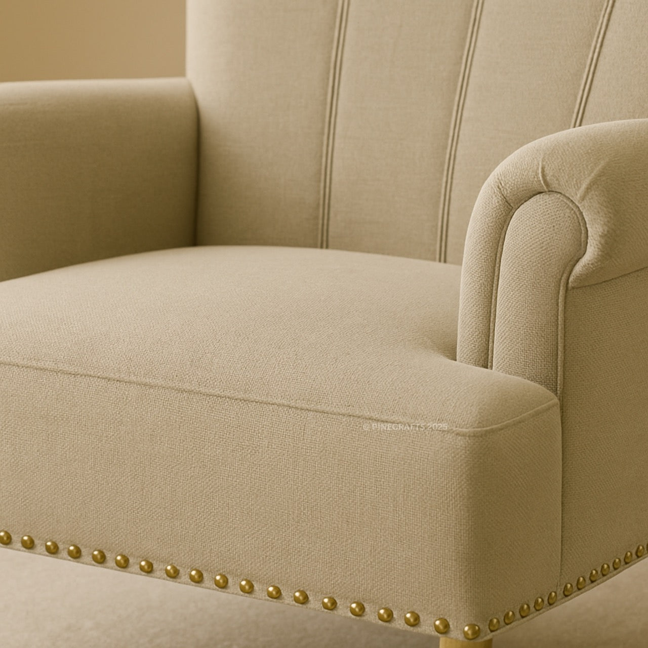 Beige armchair with gold nailhead trim on a beige background