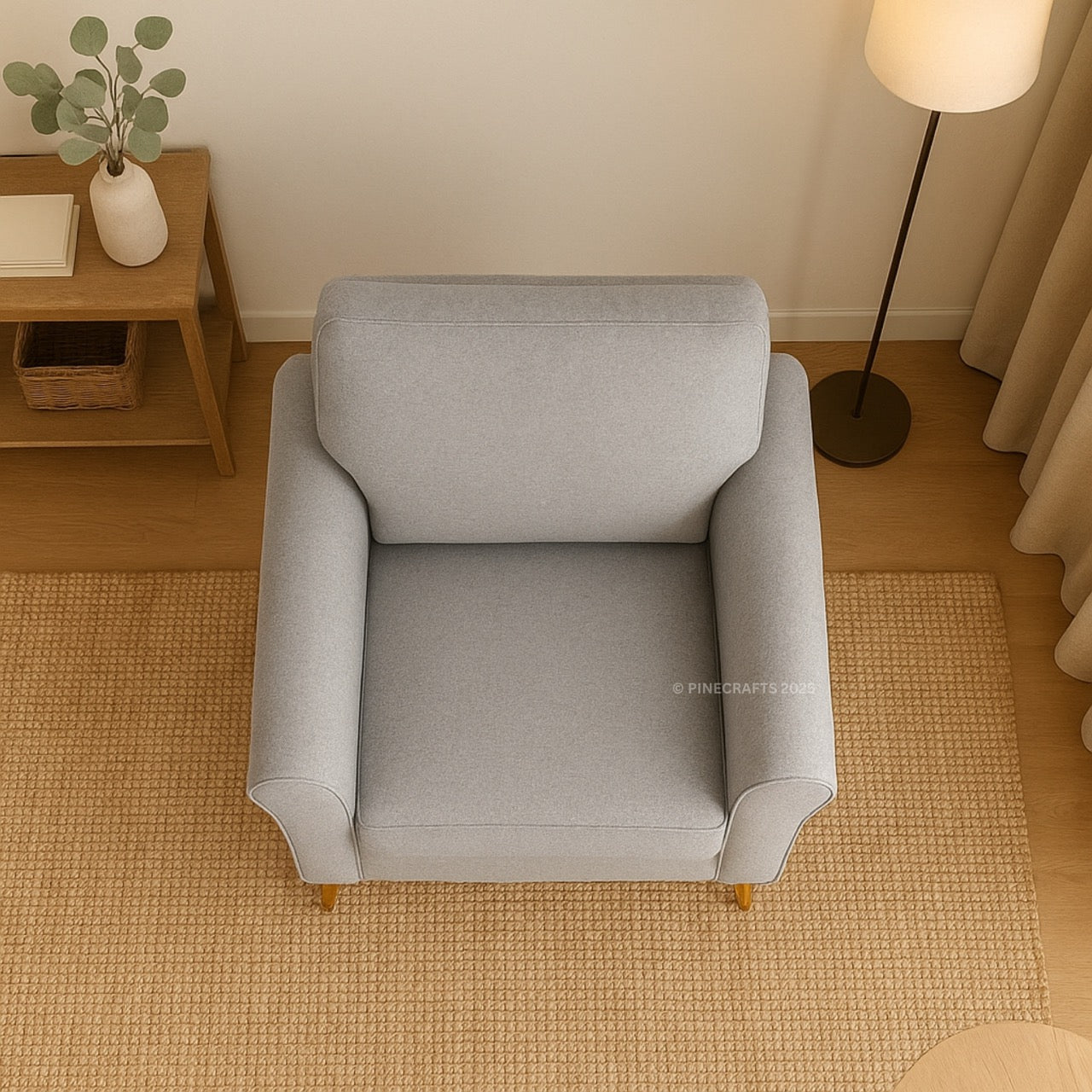 Gray armchair in a room with wooden floor and side table.