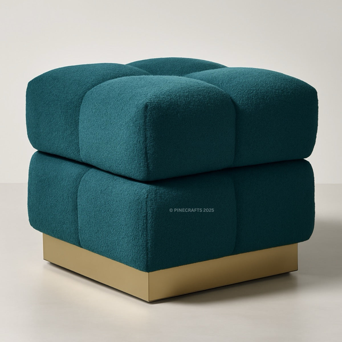 Teal ottoman with gold base on a neutral background