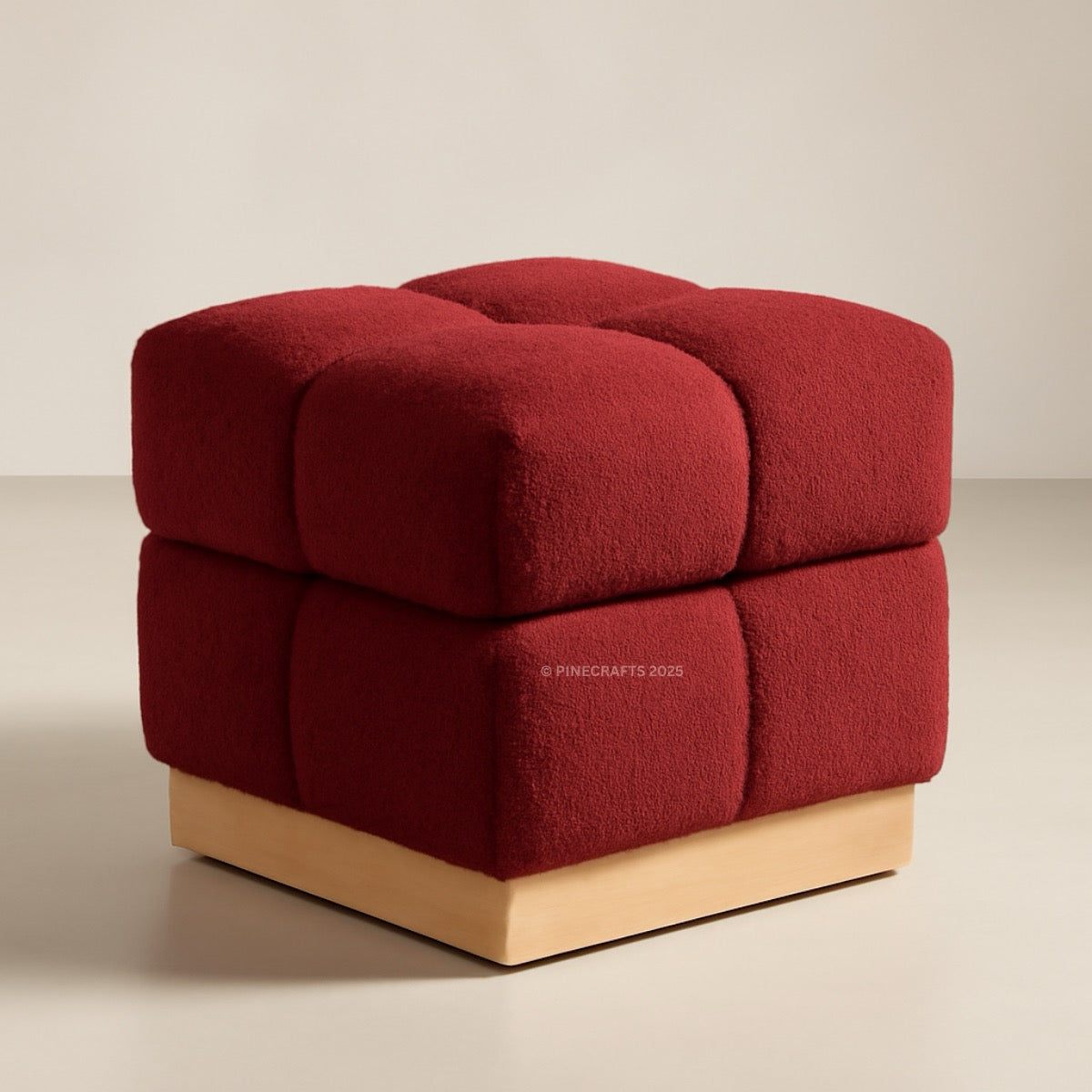 Red cube-shaped ottoman with a wooden base on a beige background