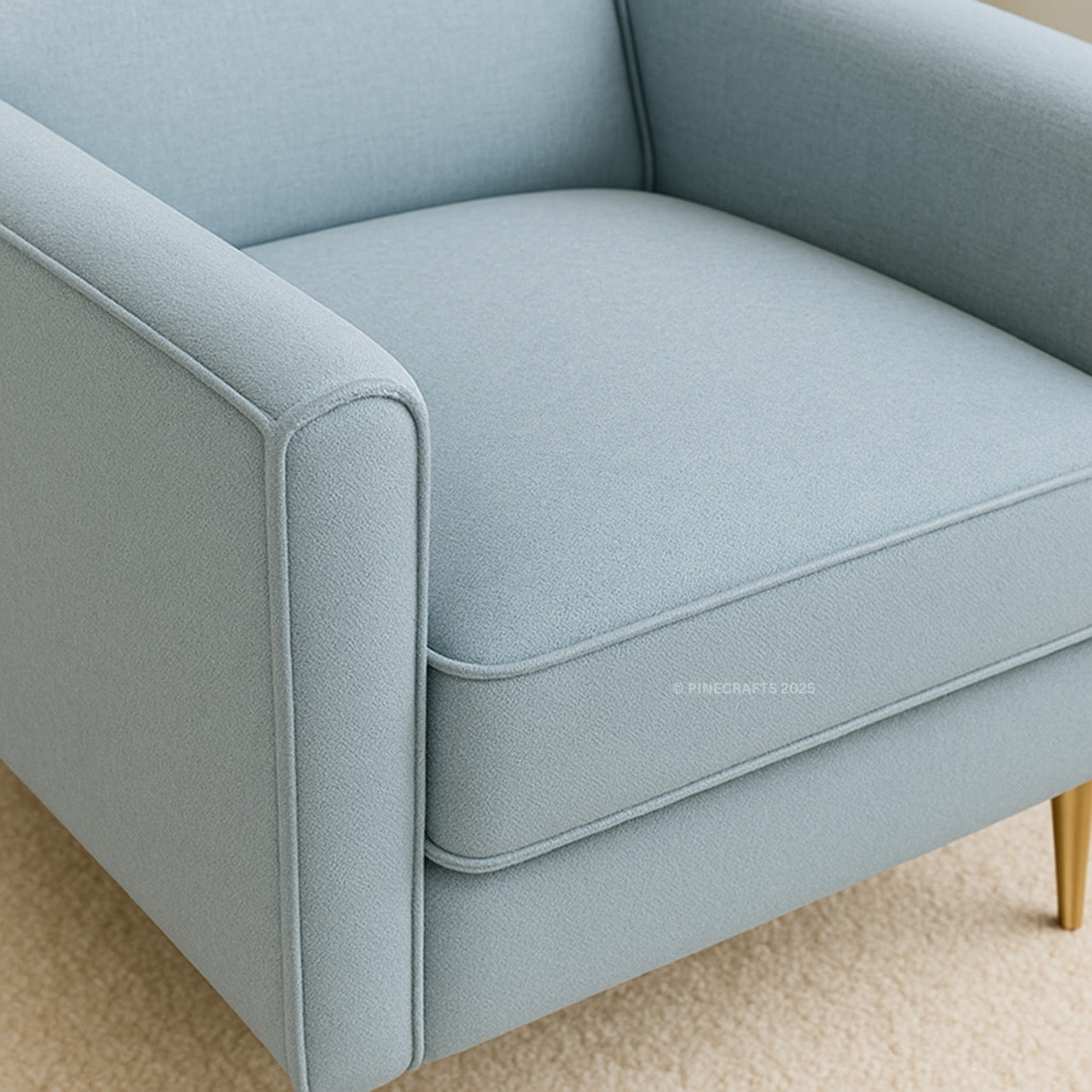Light blue sofa with gold legs on a beige carpet