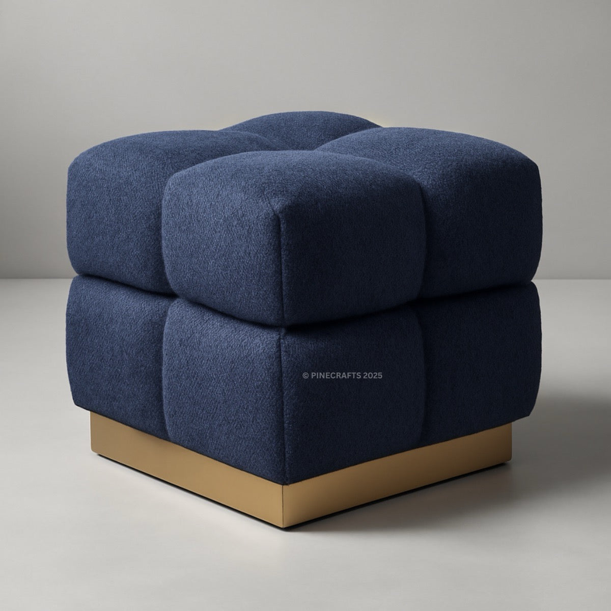 Blue cube-shaped ottoman with a wooden base on a gray background