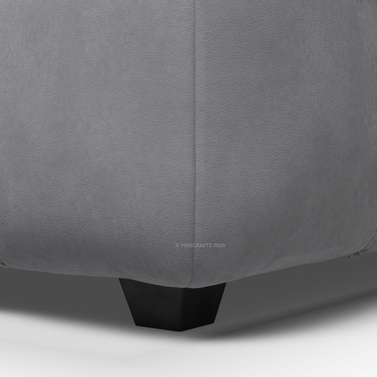 Close-up of a gray upholstered chair corner with a visible brand logo.