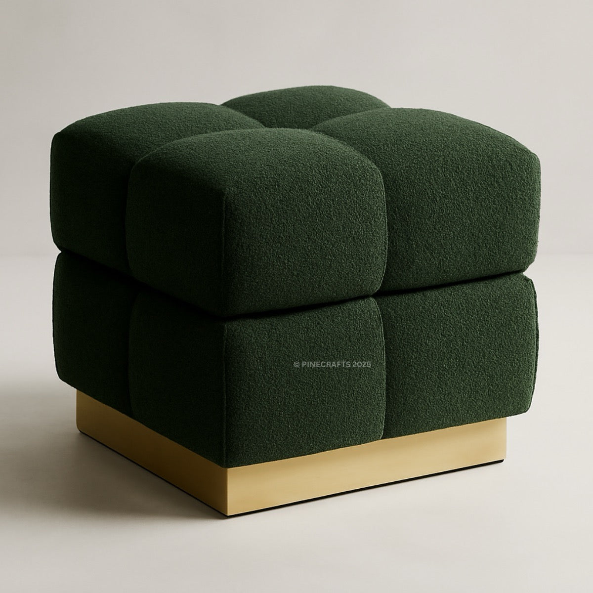 Green upholstered cube chair with gold base on a light gray background