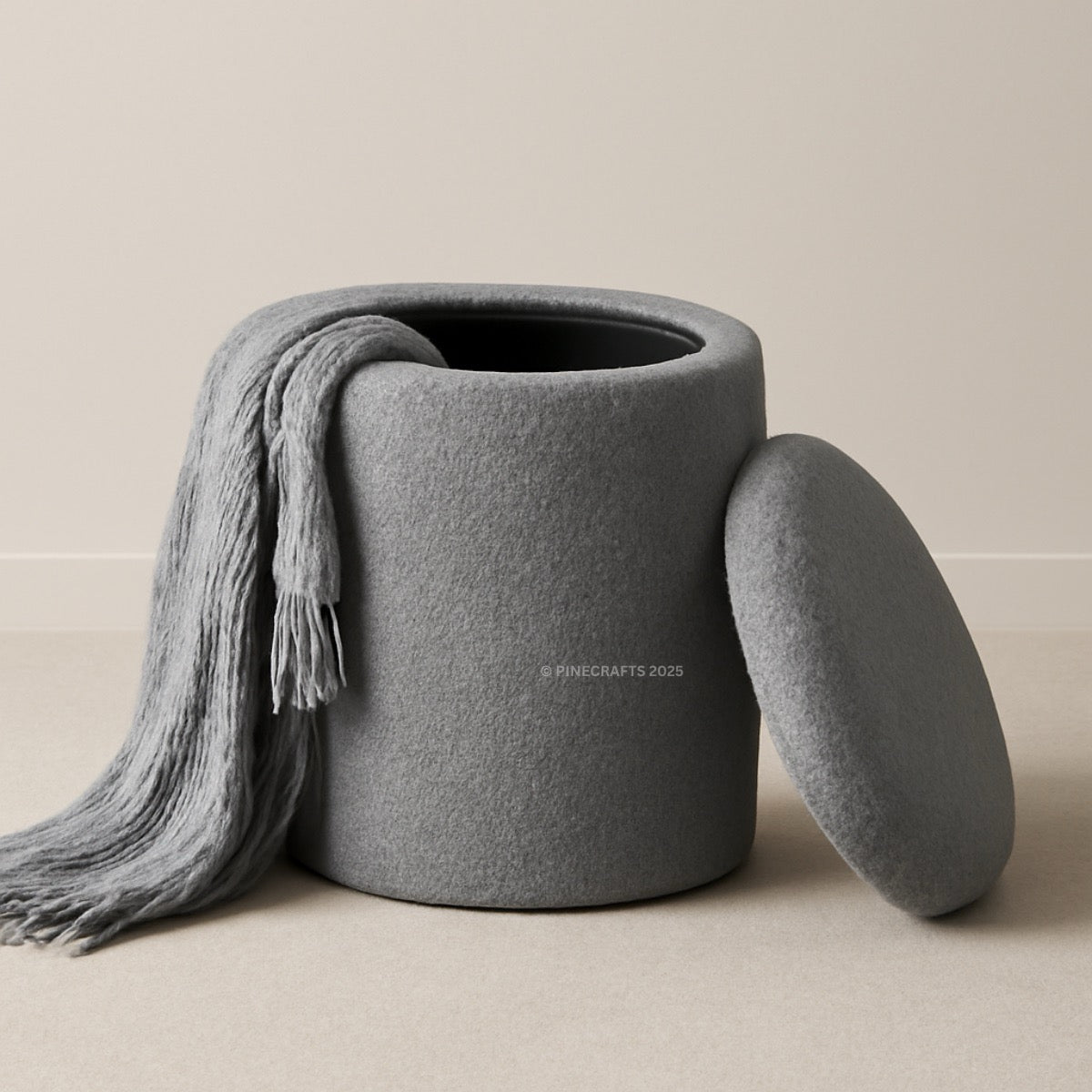 Gray textured storage jar with a matching lid and gray scarf on a beige background