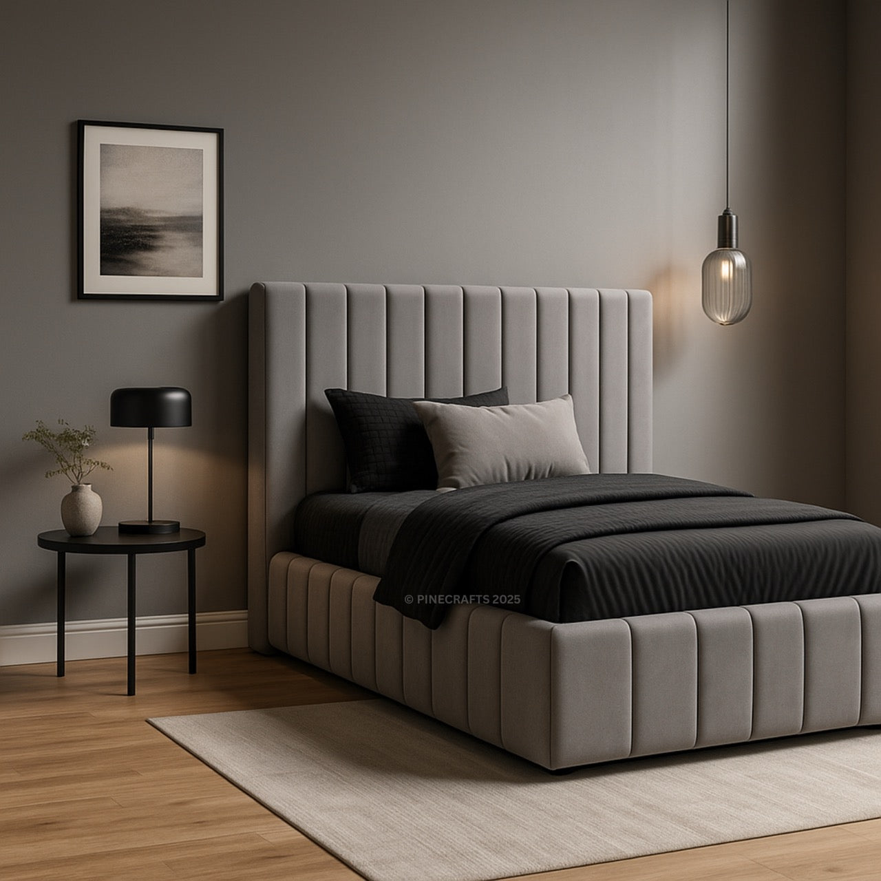 Gray upholstered bed in a bedroom with a side table and lamp.
