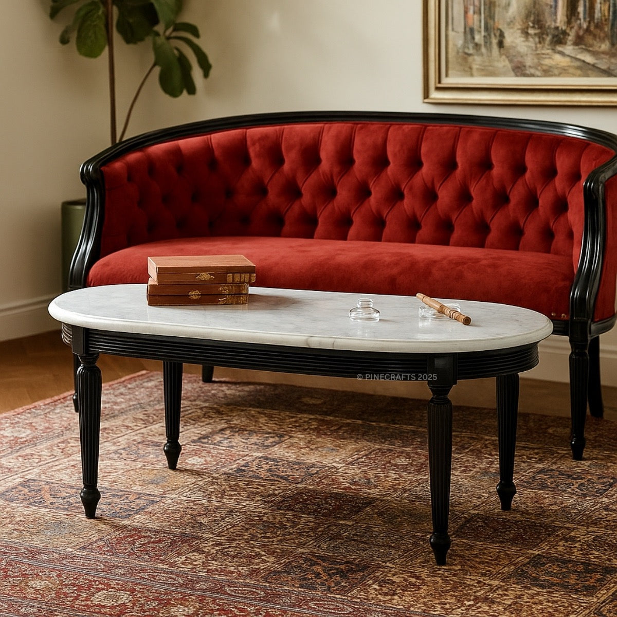 Red velvet sofa with a marble coffee table in a room with a painting on the wall.