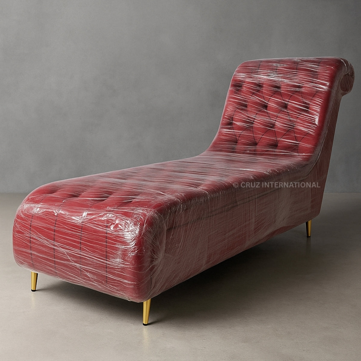 Red chaise lounge wrapped in plastic against a gray background