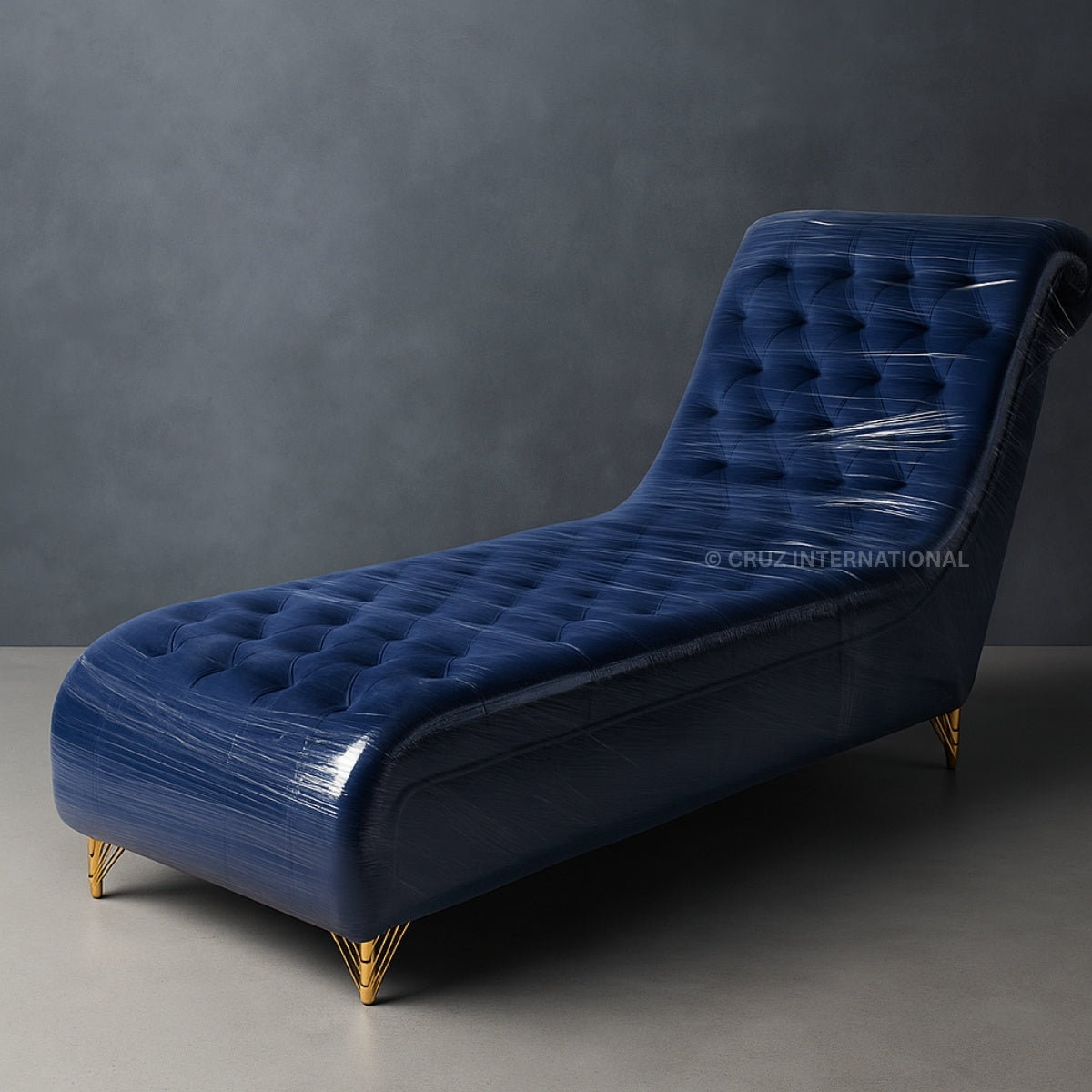 Blue tufted chaise lounge with gold legs on a gray background