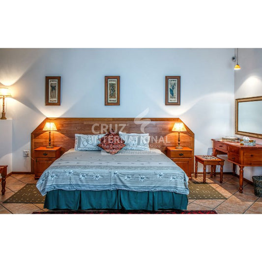 Wooden double bed with bedside tables, lamps, and vanity in a cozy modern bedroom