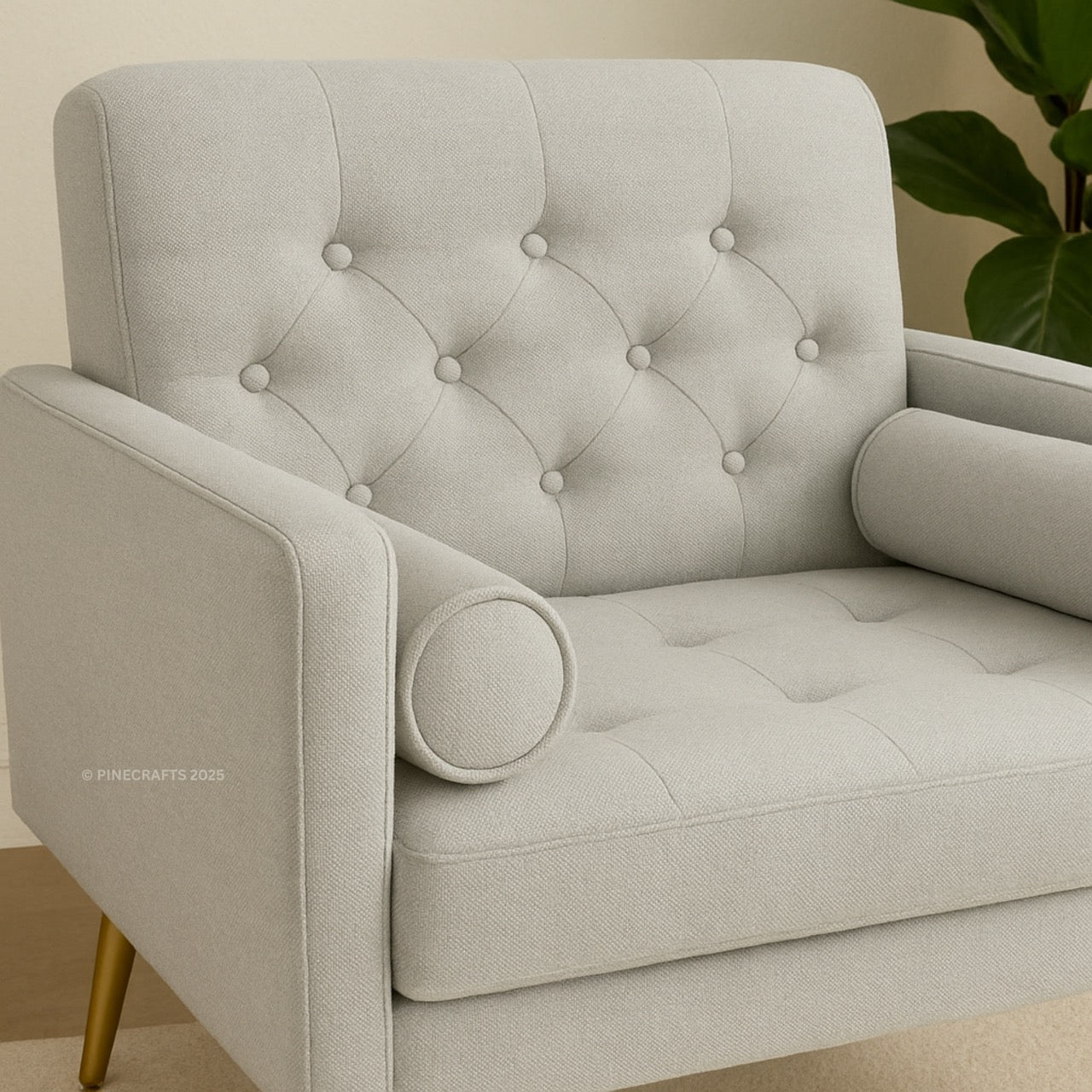 Gray tufted armchair with gold legs on a neutral background