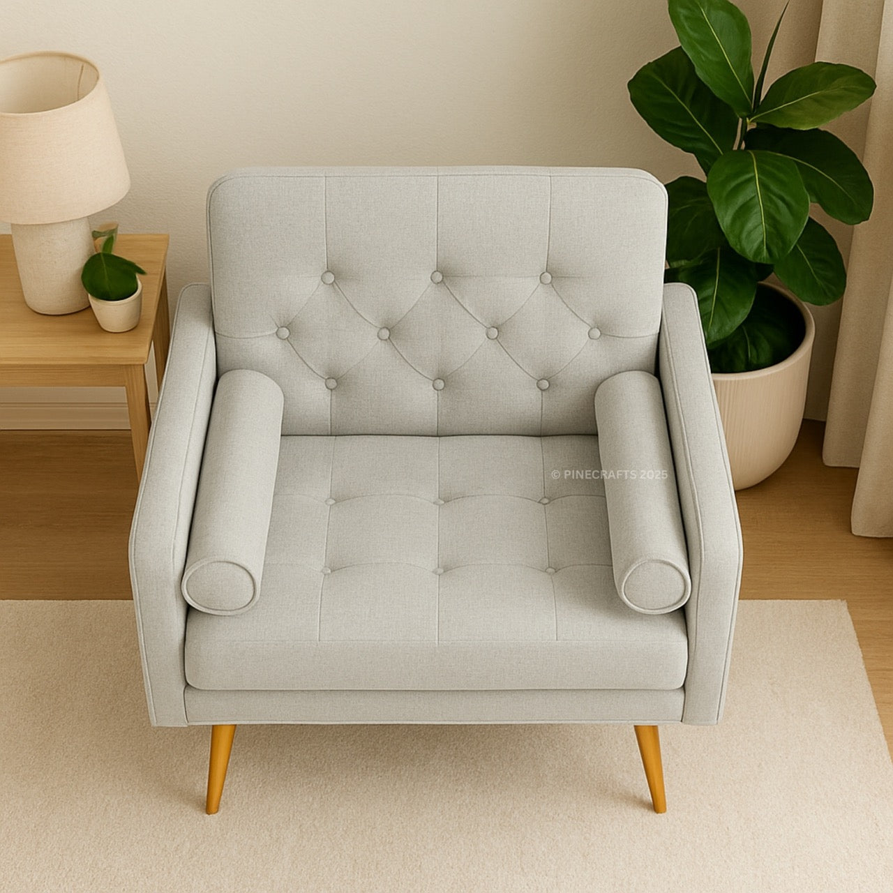 Gray tufted armchair in a room with a side table and plants.