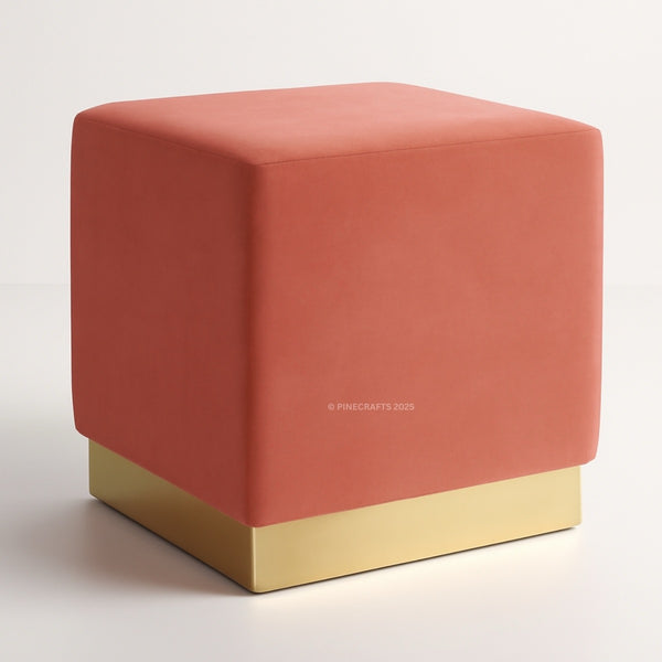 Coral cube ottoman with gold base on a white background