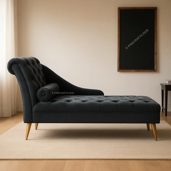 Black tufted chaise lounge in a room with a beige wall and wooden floor.
