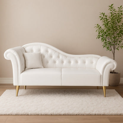 White tufted sofa with gold legs in a room with a beige wall and plant.